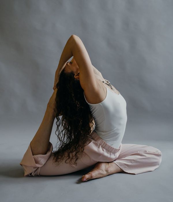 Woman in a calm yoga pose in a studio with soft lighting.